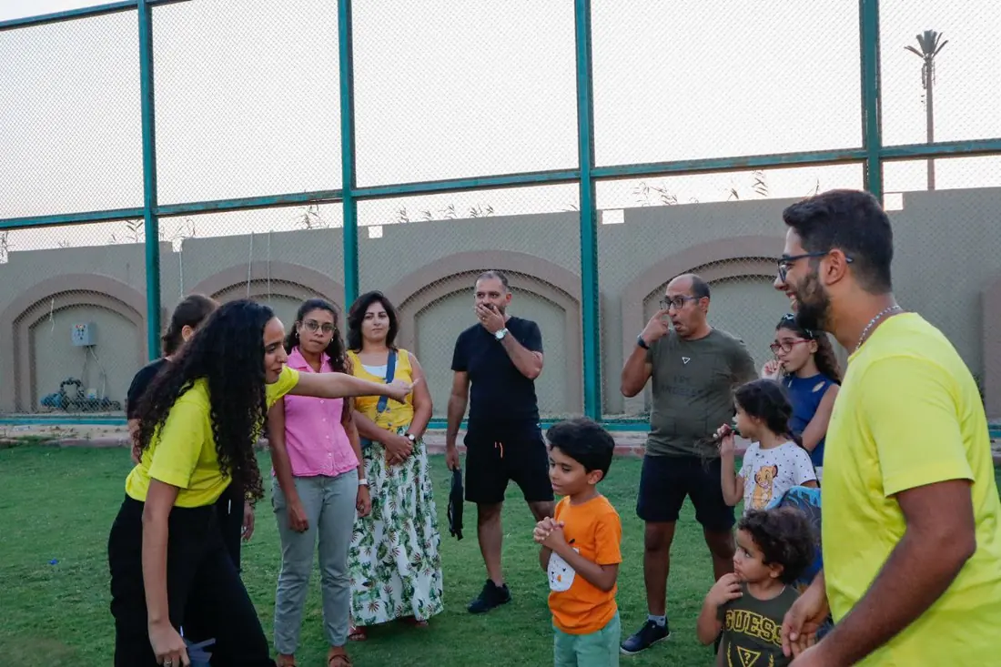 AST crew in yellow briefing a family with young children before a game
