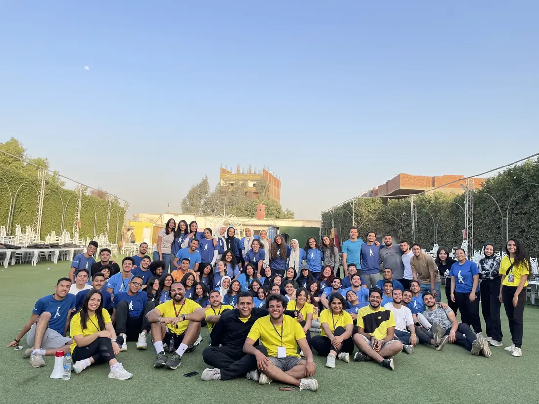 A large group in blue and yellow shirts gathered on a turf pitch